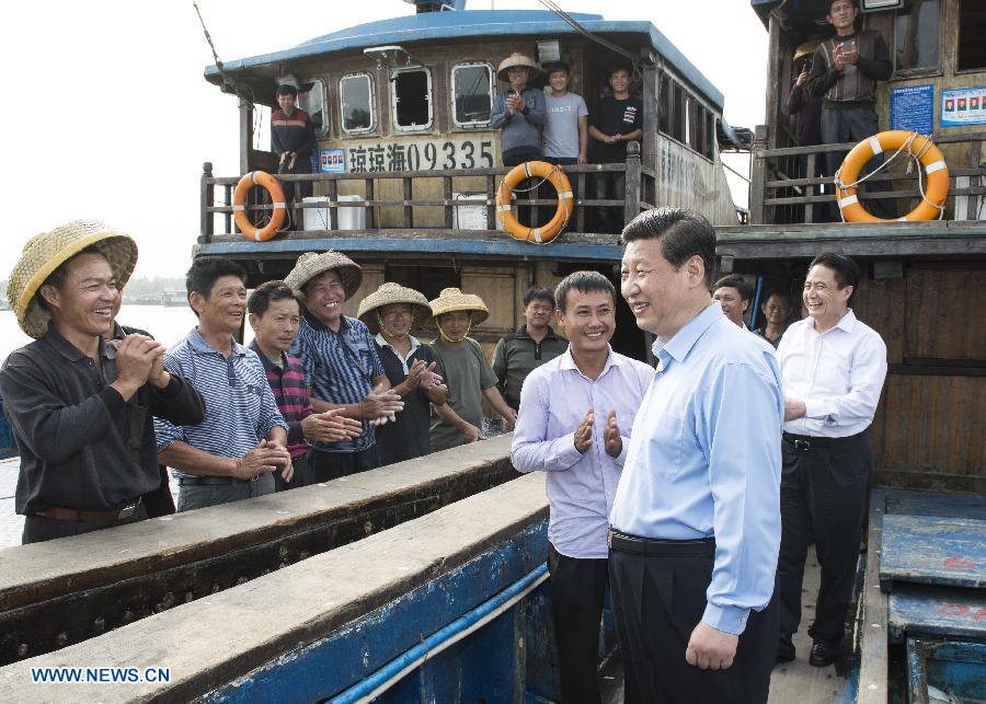 Chinese President Xi Jinping enquires fishermen about their work and life of fishing on a fishing boat at a dock in Tanmen Town of Qionghai City, south China's Hainan Province, April 8, 2013..jpg