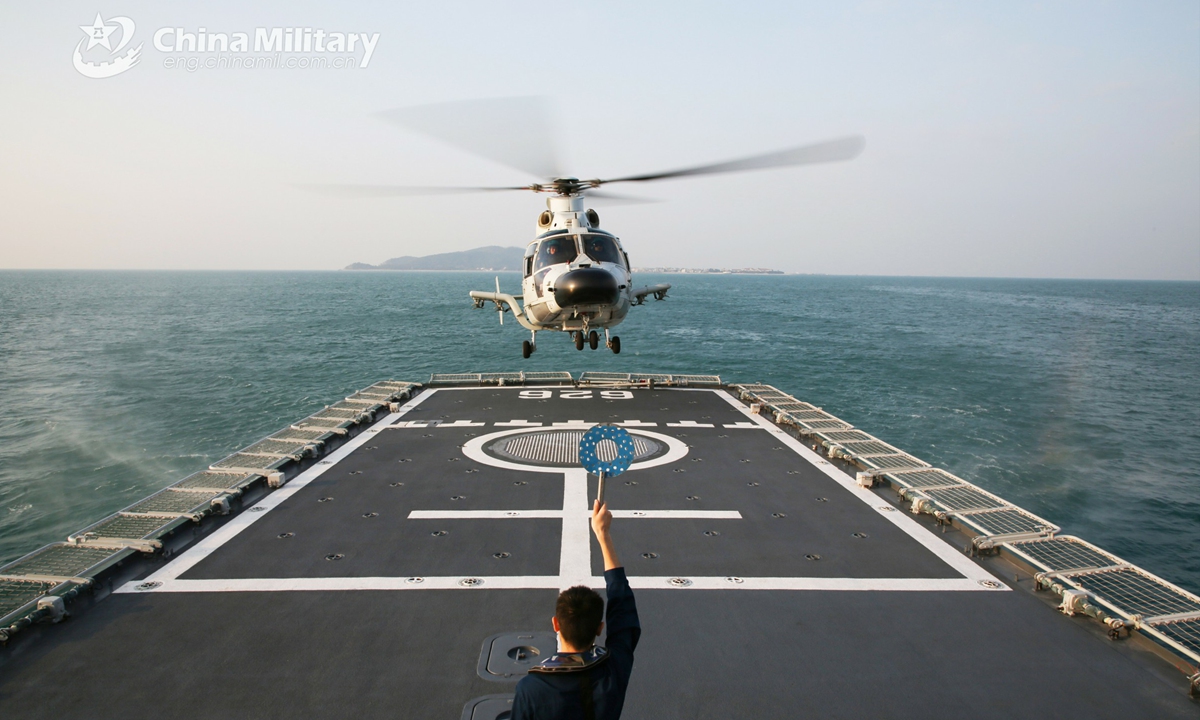 A ship-borne helicopter attached to a frigate flotilla with the navy under the PLA Southern Theater Command lands on the flight deck of the guided-missile frigate Wuzhou (Hull 626) under the guidance of a sailor during a maritime fire-fighting training operation in early December, 2021.Photo:China Military