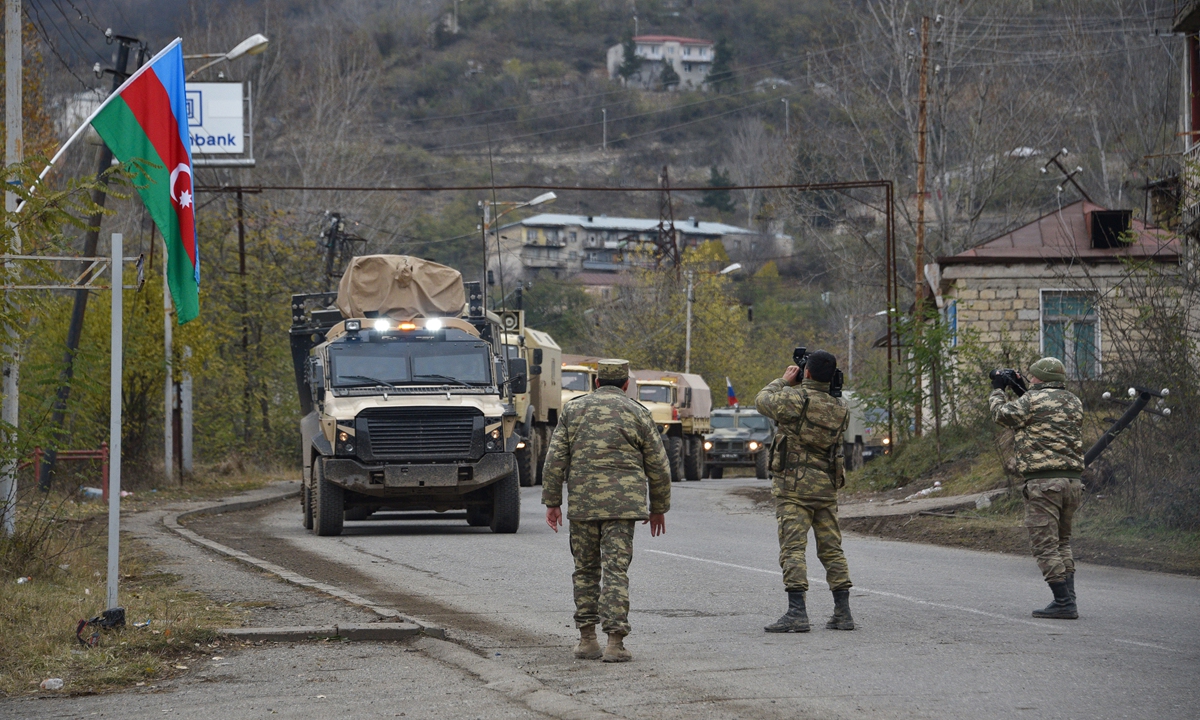 Azerbaijani soldiers film Azeri military trucks moving through the town of Lachin on Tuesday. Azerbaijani soldiers and military trucks rolled into the final district given up by Armenia in a peace deal that ended weeks of fighting over the disputed Nagorno-Karabakh region. Photo: AFP