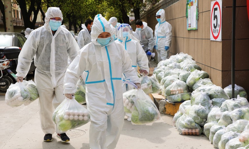 Volunteers carry daily necessities for residents in Fengxian District, east China's Shanghai, March 28, 2022.Photo:Xinhua