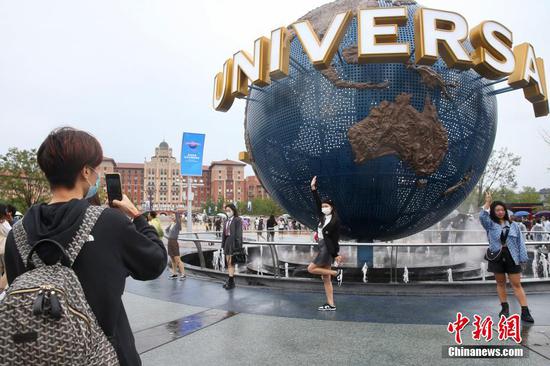 A girl takes a picture at the Universal Studios Beijing, September 20, 2021. (Photo/China News Service) 
