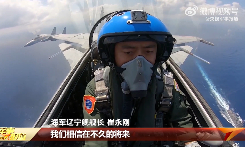 Two J-15 carrier-based fighter jets fly over what seems to be an Arleigh Burke-class destroyer at an undisclosed location at an undisclosed date. Photo: Screenshot from China Central Television