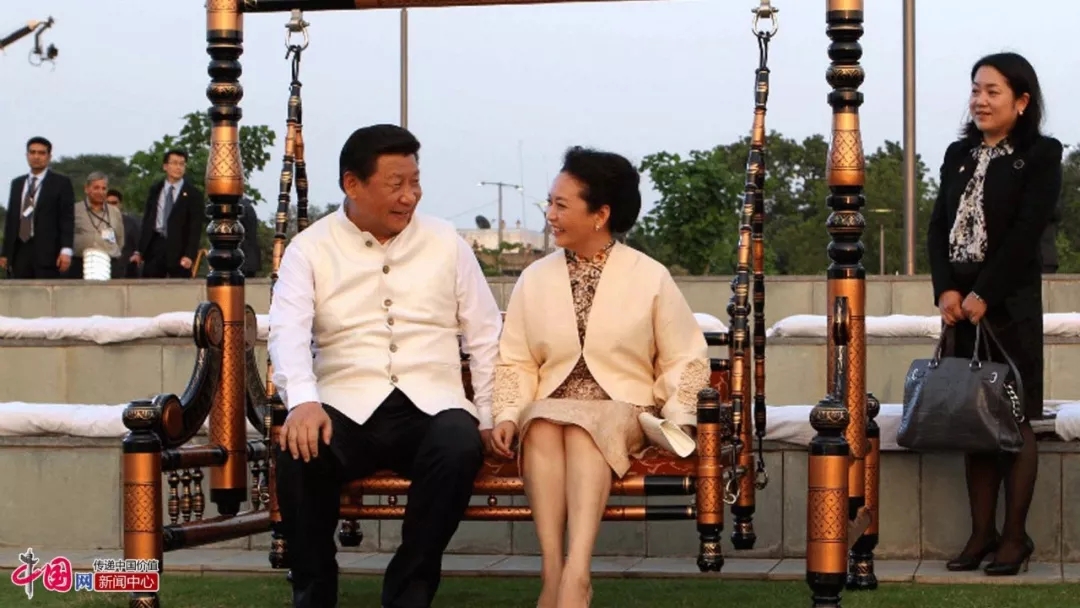 Xi Jinping and Peng Liyuan sit on a swing together during their visit to Gujarat, India in September, 2014. [File Photo: china.org.cn]