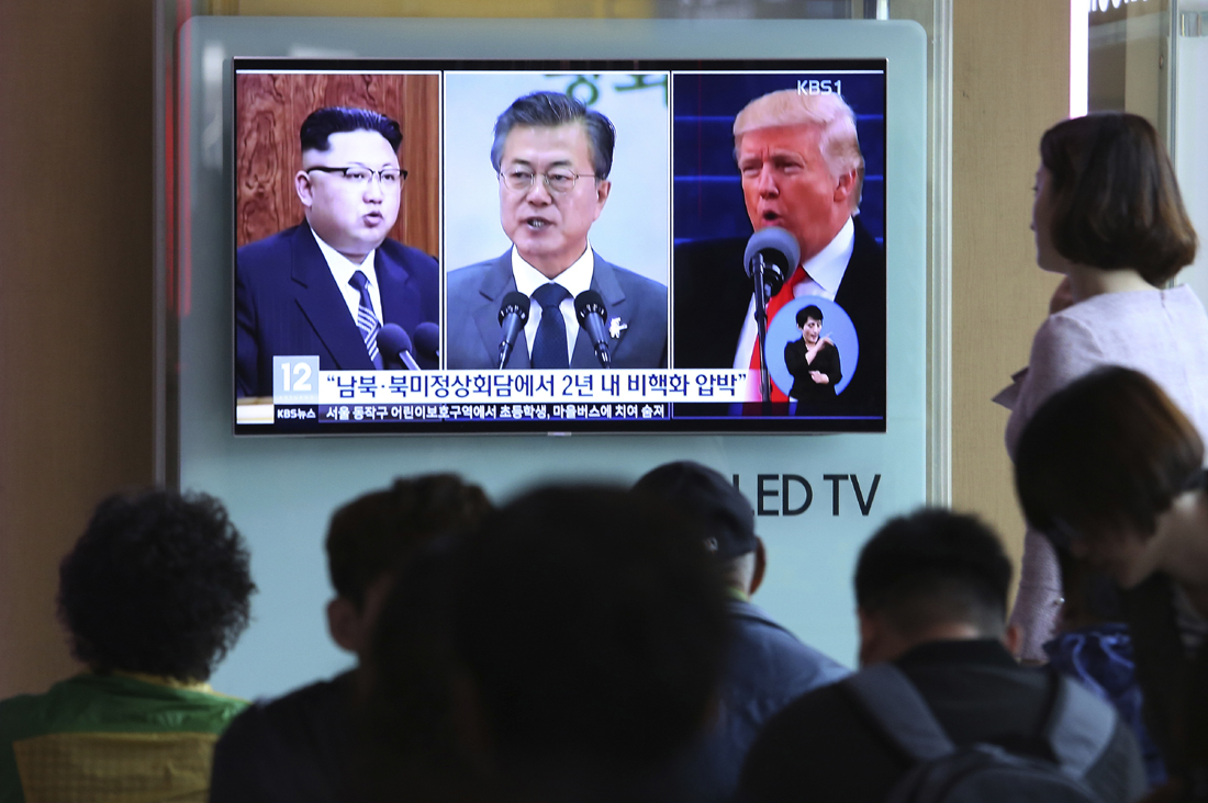 In this March 27, 2018 photo, a man watches a TV screen showing file footages of U.S. President Donald Trump, right, South Korean President Moon Jae-in, center, and North Korean leader Kim Jong Un, left, during a news program at the Seoul Railway Station in Seoul, South Korea. [File Photo: AP/Lee Jin-man]