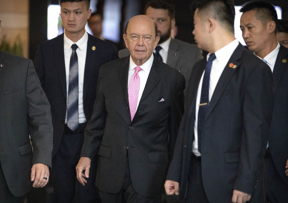 U.S. Commerce Secretary Wilbur Ross, center, leaves his hotel in Beijing, Saturday, June 2, 2018. [Photo: AP/Mark Schiefelbein]