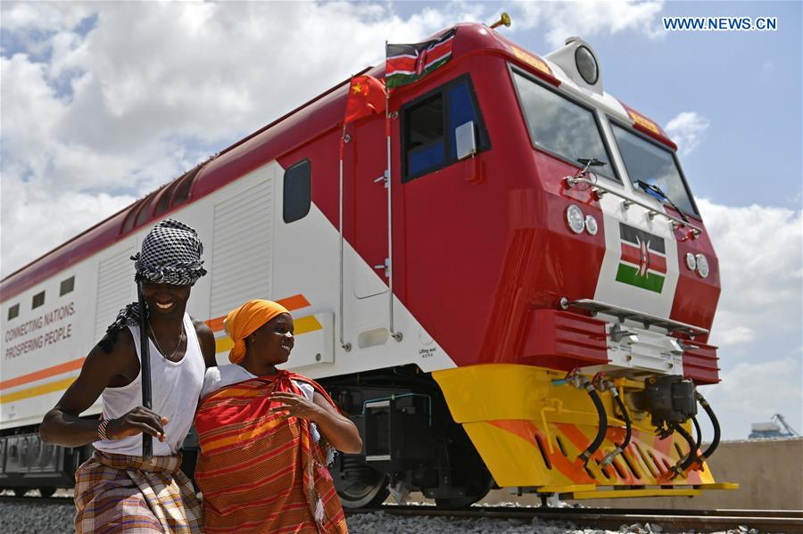 Kenyans sing and dance beside one of the first batch of locomotives for the Mombasa-Nairobi standard gauge railway in Mombasa, Kenya, on Jan. 11, 2017.[Photo: Xinhua]