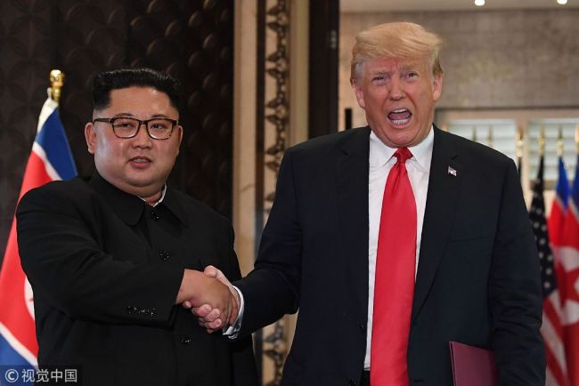 US President Donald Trump (R) and North Korea's leader Kim Jong Un shake hands following a signing ceremony during their historic US-North Korea summit, at the Capella Hotel on Sentosa island in Singapore on June 12, 2018. Donald Trump and Kim Jong Un became on June 12 the first sitting US and North Korean leaders to meet, shake hands and negotiate to end a decades-old nuclear stand-off. [Photo: VCG]