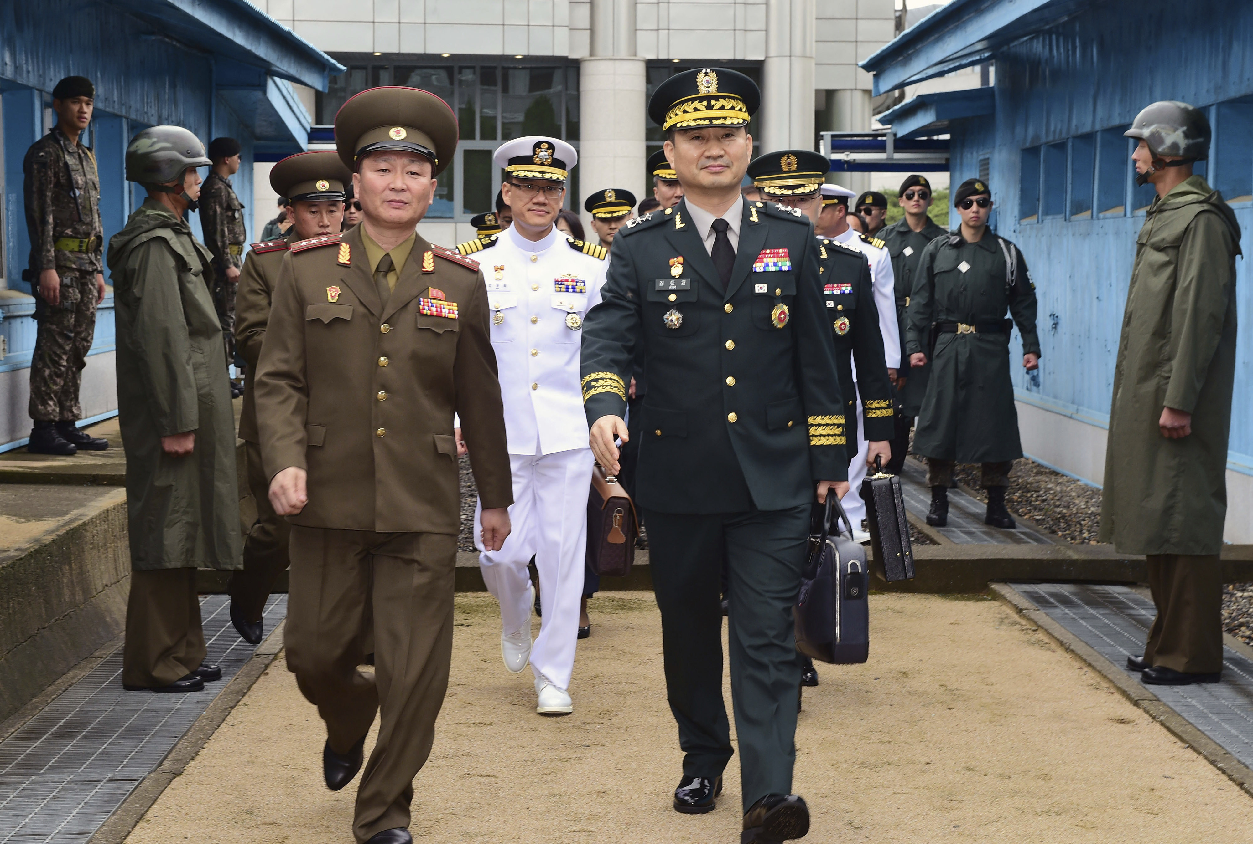 In this photo provided by the South Korea Defense Ministry, South Korean Maj. Gen. Kim Do-gyun, center right, is escorted by a North Korean officer after crossing to North Korea for the meeting at the northern side of Panmunjom in the Demilitarized Zone, North Korea, Thursday, June 14, 2018. The two Koreas were holding rare high-level military talks Thursday to discuss reducing tensions across their heavily fortified border. [Photo: South Korea Defense Ministry via AP]