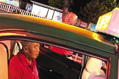 45-year-old Li Jinzhu waits for passengers outside the taxi, as his father sits inside the vehicle, accompanying his son. [File Photo: The Beijing News]