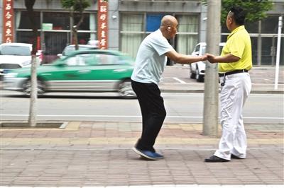 Li Jinzhu helps his father walk a little bit outside the taxi. [File Photo: The Beijing News]