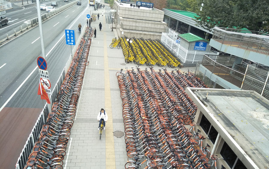 Hundreds of Mobikes and Ofos parked outside a subway station in Beijing. [Photo: China Plus]