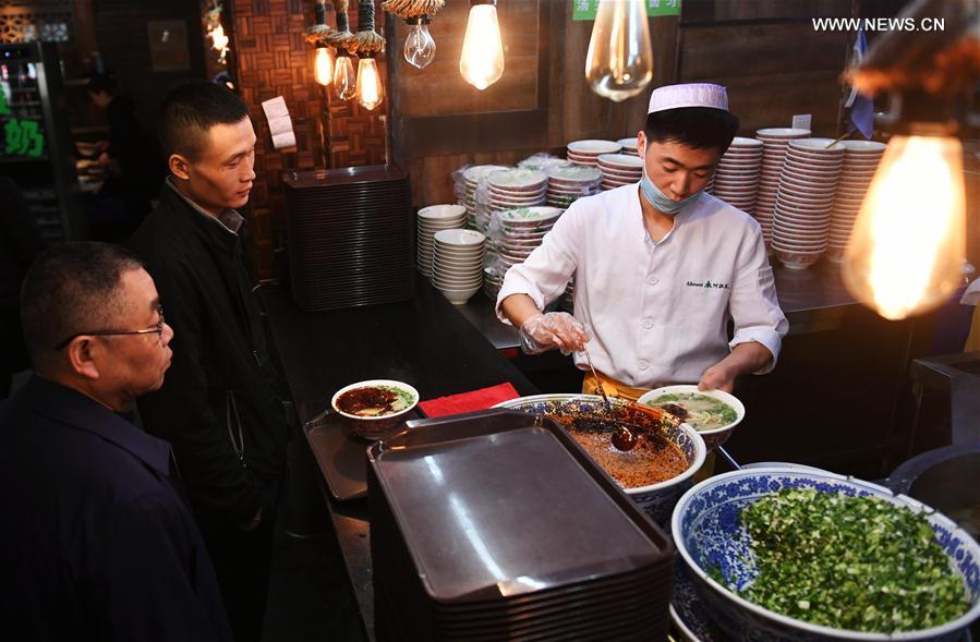 A chef prepares a bowl of beef noodle at a noodle restaurant in Lanzhou, capital of northwest China's Gansu Province, April 12, 2017. As a piece of name card of Lanzhou City, beef noodle is an indispensable food of local people. There are more than 1,000 beef noodle cookshops in Lanzhou and they can sell over one million bowls of beef noodle every day. [Photo: Xinhua]