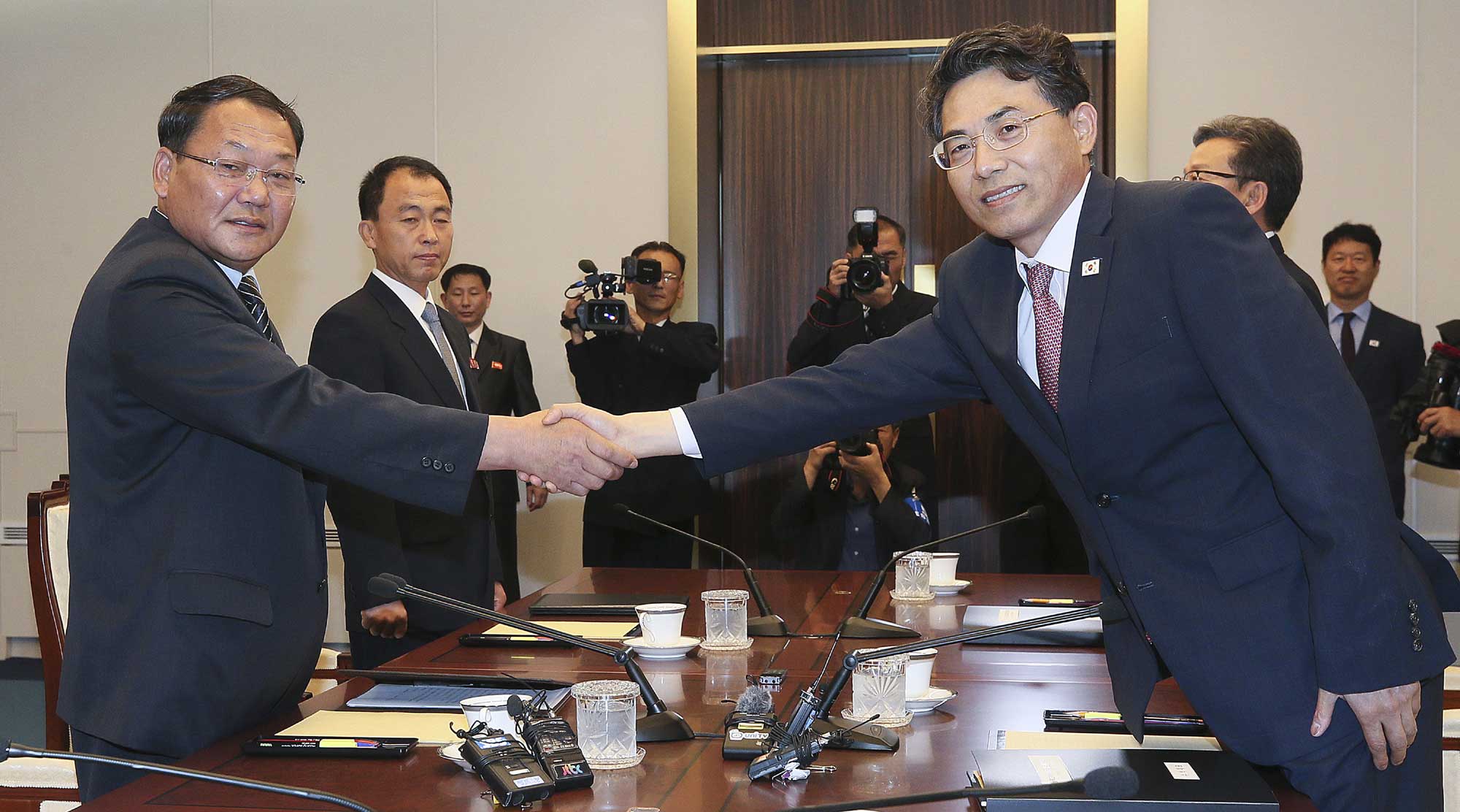 DPRK vice Railroad Minister Kim Yun Hyok, left, shakes hands with his South Korean counterpart vice Transport Minister Kim Jeong-ryeol during a meeting to discuss over inter-Korean cooperation in railway inside the Peace House at the border village of Panmunjom, South Korea, Tuesday, June 26, 2018. [Photo: Korea Pool via AP]