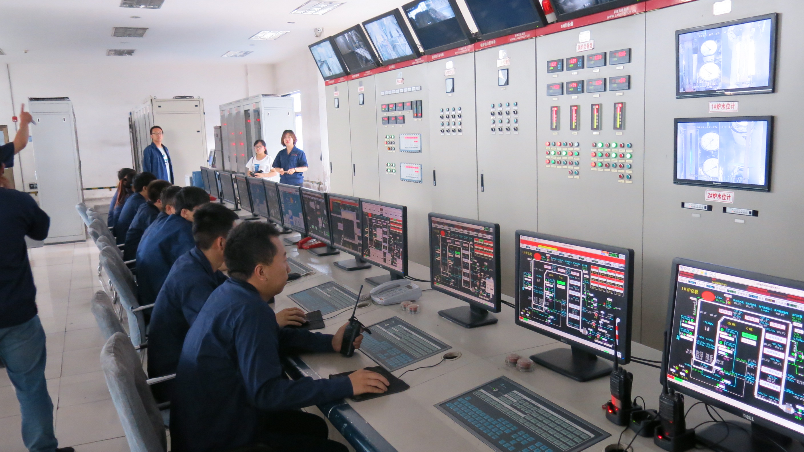 Employees in the control room monitor data from the Shanxi Xinshitai Green Energy power plant. [Photo by Chris Georgiou / China.org.cn]