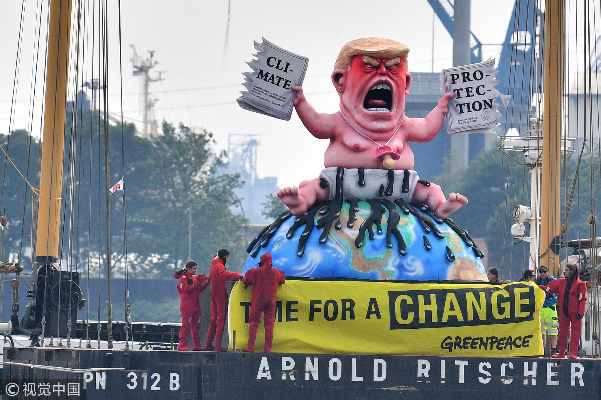 Greenpeace activists protest on a boat with a giant figure featuring US President Donald Trump as a baby, tearing up a climate protection document, on July 7, 2017, in Hamburg, northern Germany. [Photo: VCG]