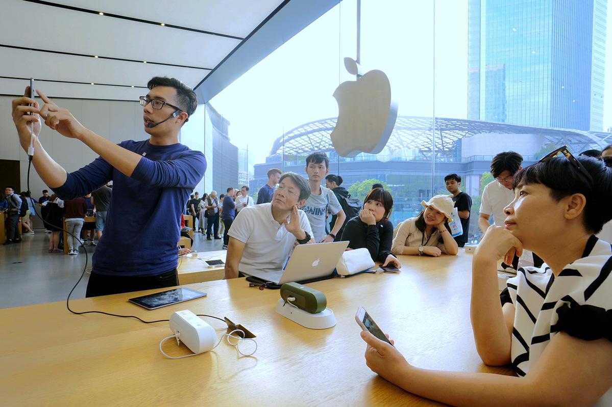 Customers check out iPhones at an Apple store in Guangzhou, capital of Guangdong province. [Photo/China Daily]