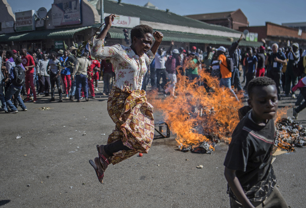 Opposition MDC party supporters protest in the streets of Harare during clashes with police Wednesday, Aug. 1, 2018. [Photo: AP/Mujahid Safodien]