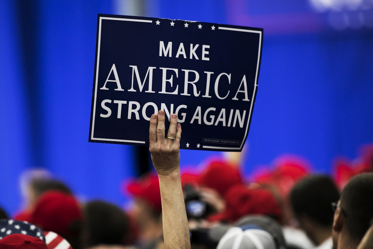 A person holds slogan at Trump’s “Make America Great Again (MAGA)” rally, August 4, 2018. [Photo: VCG]
