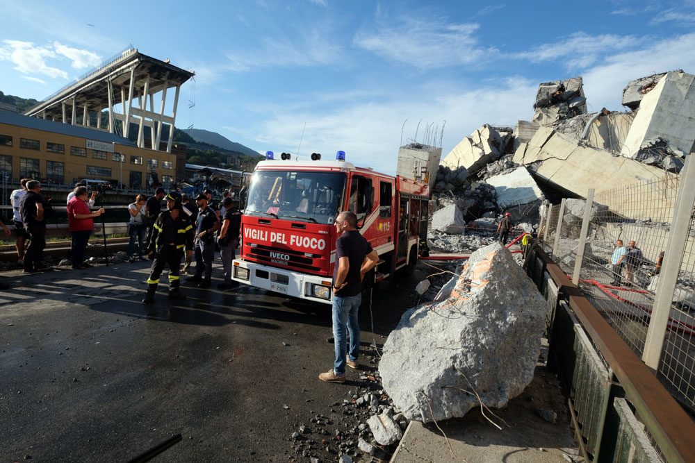 Rescuers inspect the rubble and wreckages by the Morandi motorway bridge after a section collapsed earlier in Genoa on August 14, 2018. [Photo: AFP/Andrea Leoni]