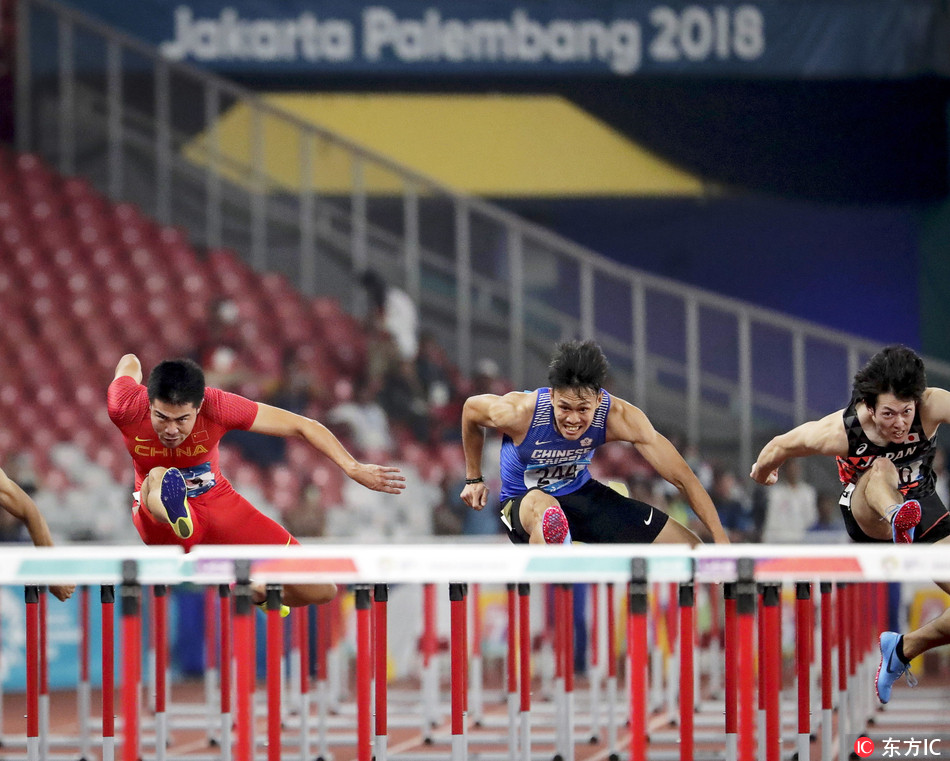 China's Xie Wenjun (L) is on his way to win the gold medal in the men's 110m Hurdles final of the Athletics events at the Asian Games 2018 in Jakarta, Indonesia, 28 August 2018. Xie Wenjun won ahead of second placed Chen Kuei-ru (C) of Taiwan and third placed Shunya Takayama (R) of Japan. [Photo: MAST IRHAM/ IC]