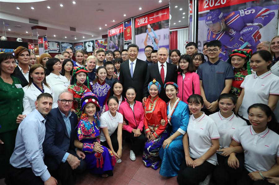 Chinese President Xi Jinping and Russian President Vladimir Putin pose for photos with youths from China and Russia and faculty representatives as they visit the All-Russian Children's Center "Ocean" in Vladivostok, Russia, Sept. 12, 2018. [Photo: Xinhua]