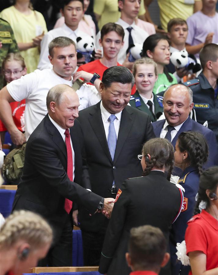 Chinese President Xi Jinping and Russian President Vladimir Putin talk with children at the All-Russian Children's Center "Ocean" while attending commemoration events marking the 10-year anniversary of the center's hosting of hundreds of Chinese children from regions hit by a deadly earthquake in 2008, in Vladivostok, Russia, Sept. 12, 2018. [Photo: Xinhua]