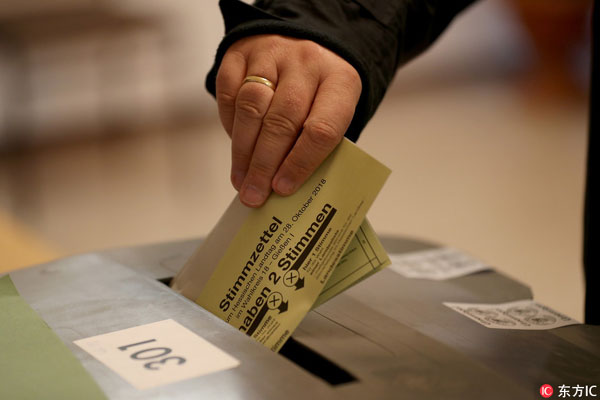 A voter casts his ballot during the Hesse state elections at a polling station in Giessen, Germany, October 28th, 2018. According to the Statistical Office of Hesse some 4.4 million people are eligible to vote in the regional elections for a new parliament in the German state of Hesse. [Photo: Imagine China]