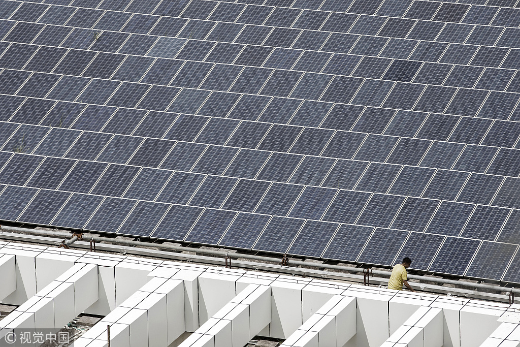 A worker walks past a rooftop solar farm at the BYD Co. headquarters in Shenzhen, China, September 21, 2017.[Photo:VCG]