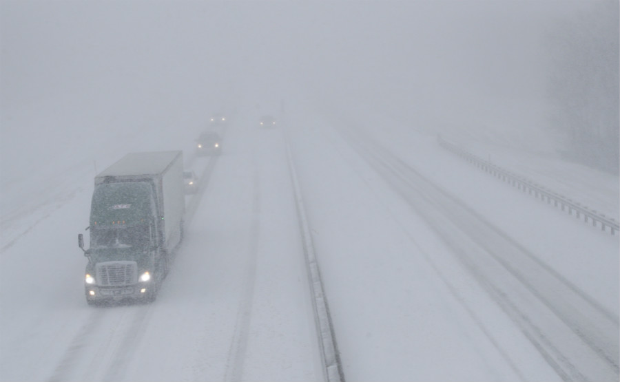 Pedestrians walk along a snow-covered street in Kansas City, Mo. on Sunday, Nov. 25, 2018. Blizzard-like conditions have closed highways and delayed air travel as a winter storm moves across the Midwest. [Photo: AP]