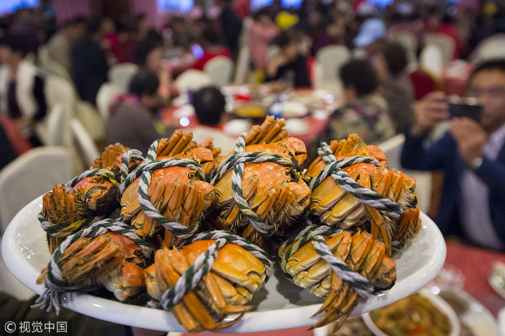 Visitors taste local crabs in Nanton, Jiangsu Province on November 2, 2018. Jiangsu Province is famous for its delicious Yangcheng Lake Chinese Mitten Crabs. [Photo: VCG]