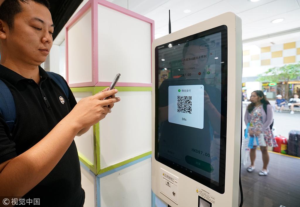 A man scans a QR code in a retail store in China.[Photo:VCG]