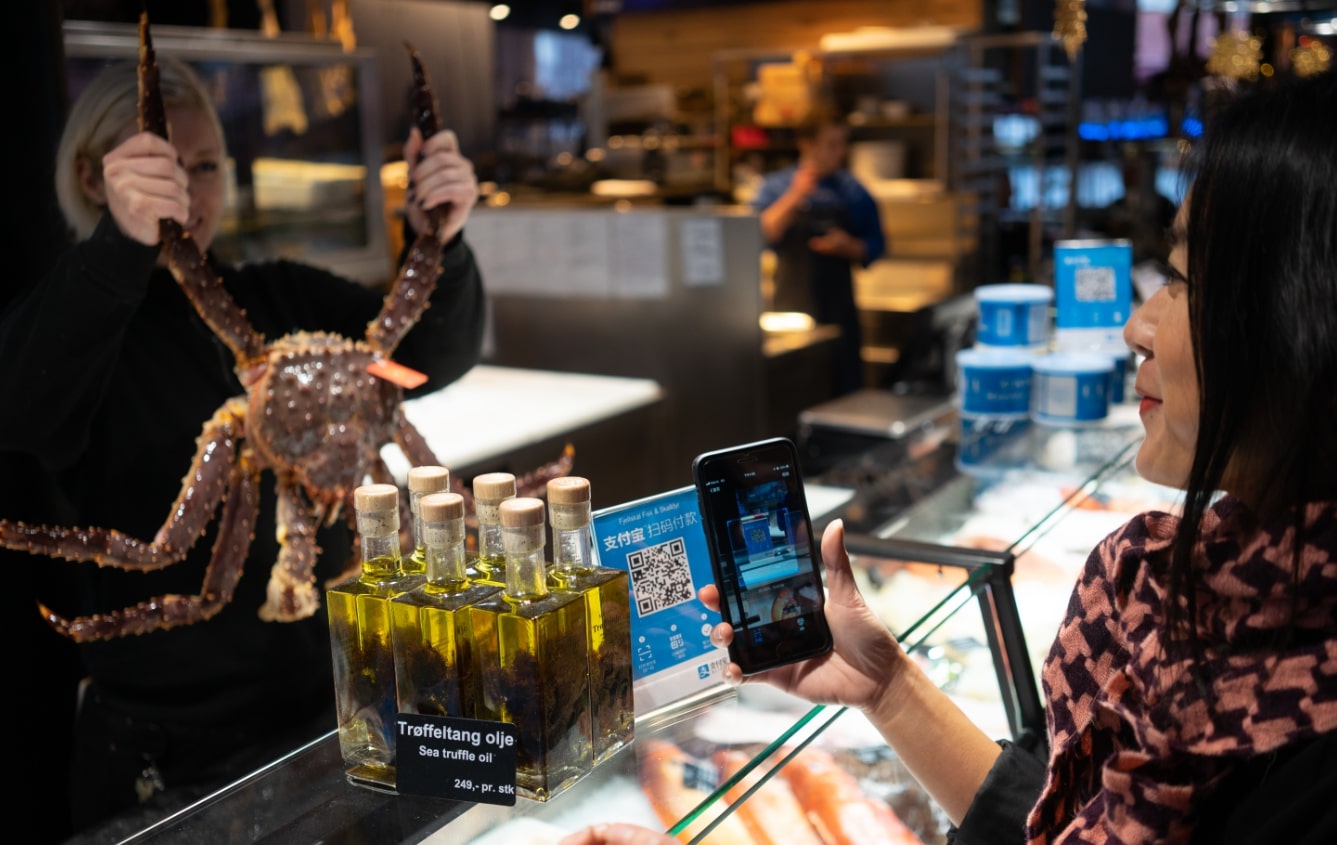 A tourist uses Alipay to pay at Fjellskal, Norway's most famous fish market. [Photo provided to China Plus]