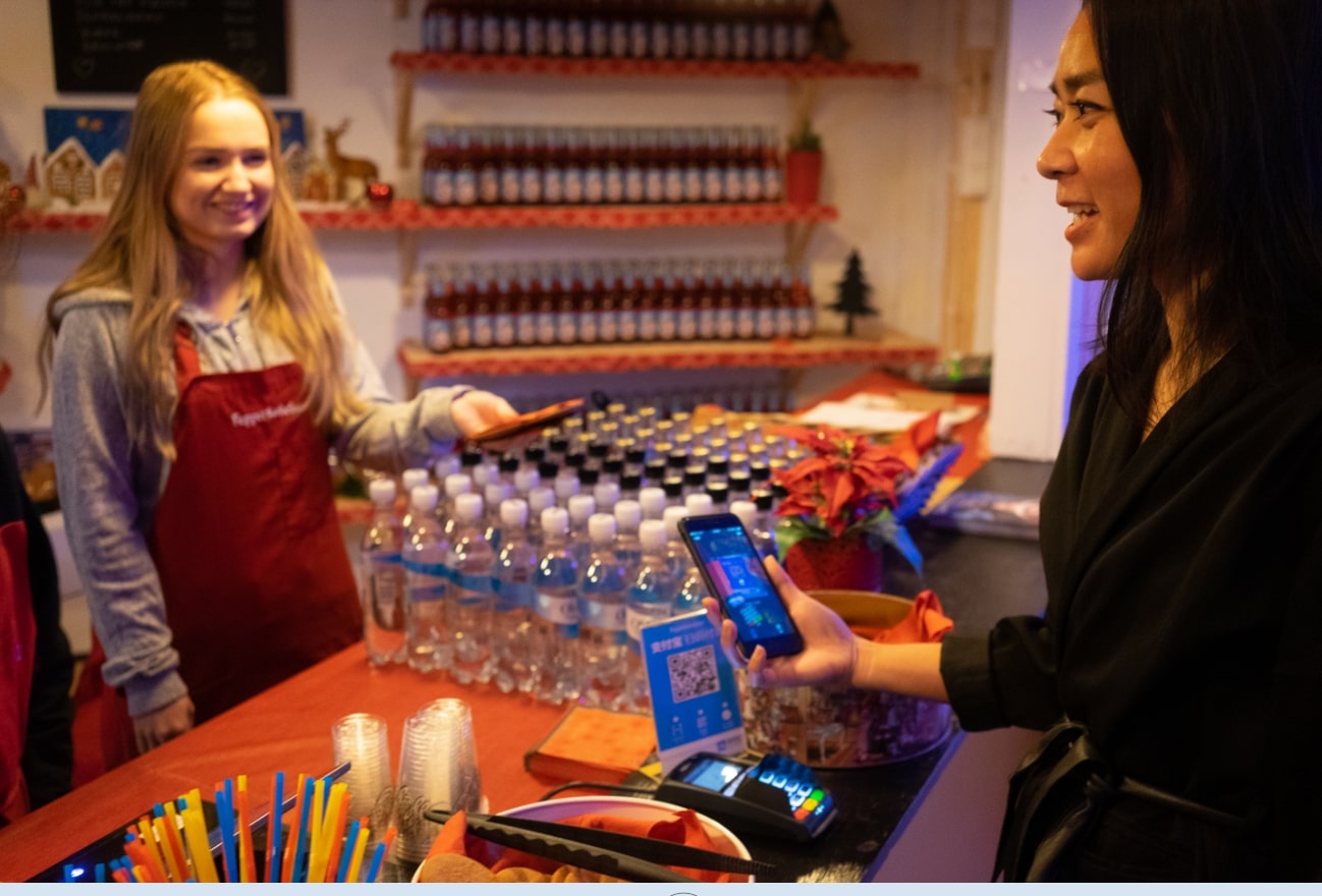 A tourist uses Alipay to pay at Bergen's Pepperkakebyen, the world's largest gingerbread city. [Photo provided to China Plus]