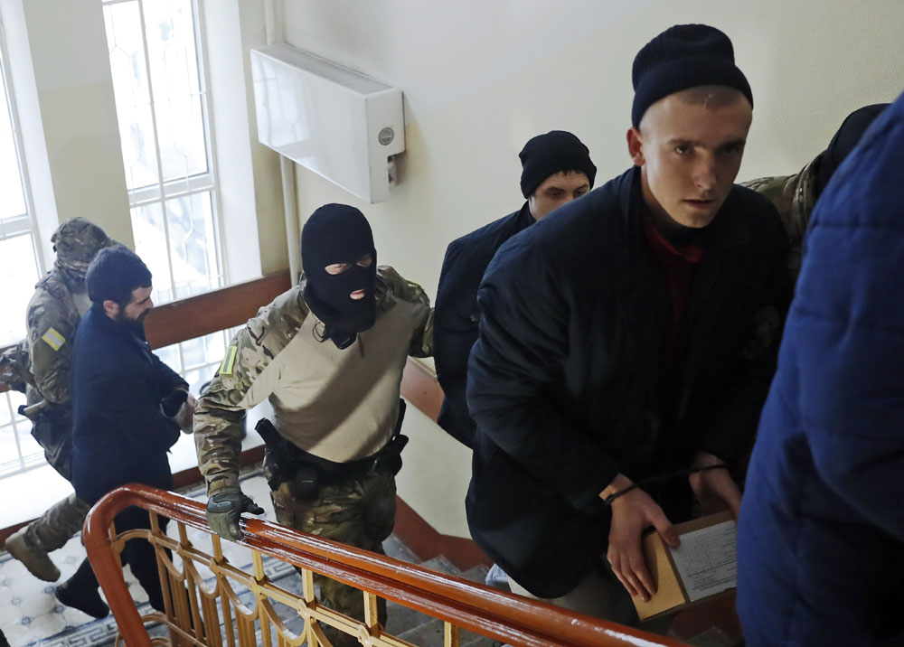 Ukrainian sailors are escorted by Russian intelligence agency officers to a court room in Moscow, Russia, Tuesday, Jan. 15, 2019. [Photo: AP/Pavel Golovkin]