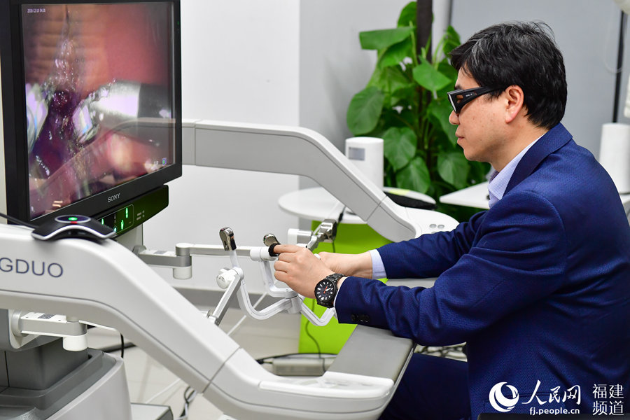 Doctor Liu Rong operates remotely during surgery on a pig using 5G technology in Fuzhou, Fujian Province. [Photo: people.cn]