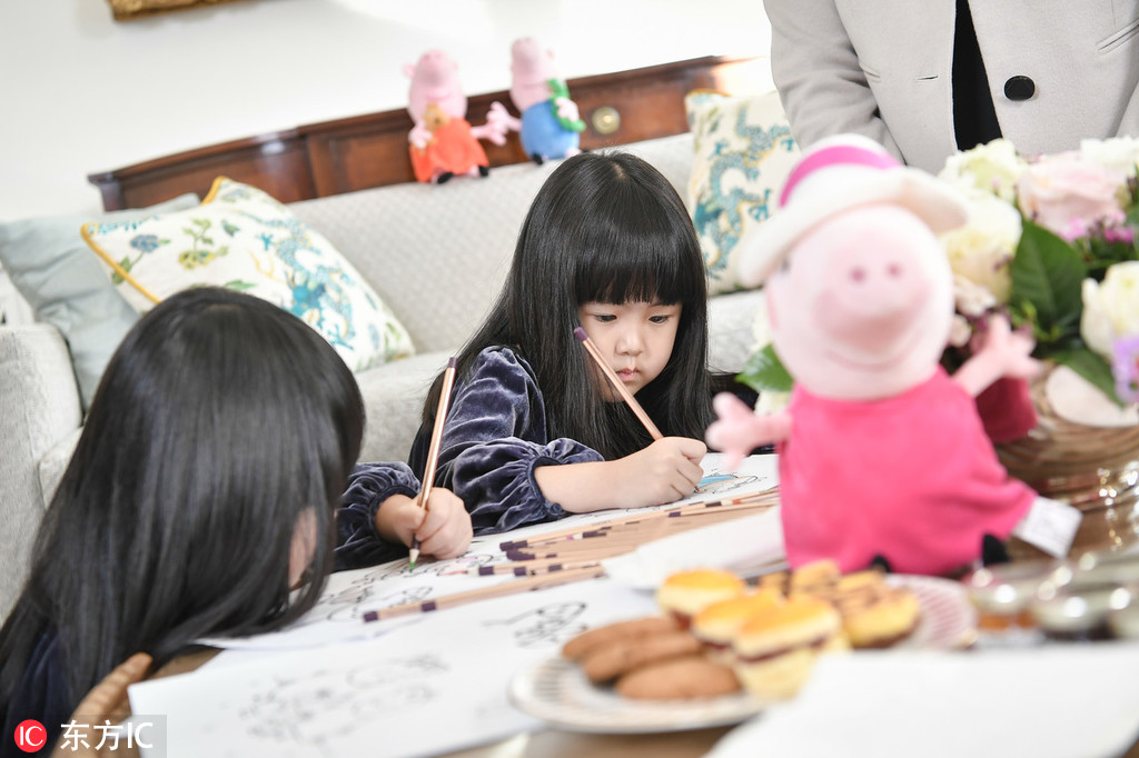 Peppa Pig fans Mi Ai and Mi Ni make paintings during afternoon tea with the British Ambassador to China Barbara Woodward at the British Embassy in Beijing on Monday, January 21, 2019. [Photo: IC]