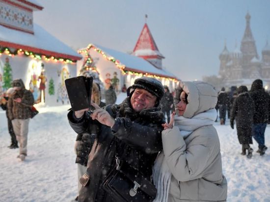 People enjoy snow at Red Square in Moscow