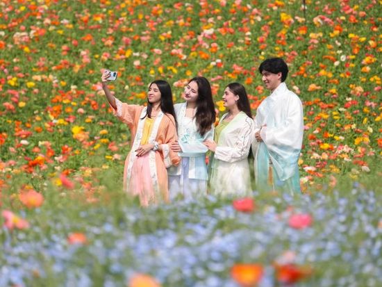 People enjoy blooming flowers in China's Jiangsu