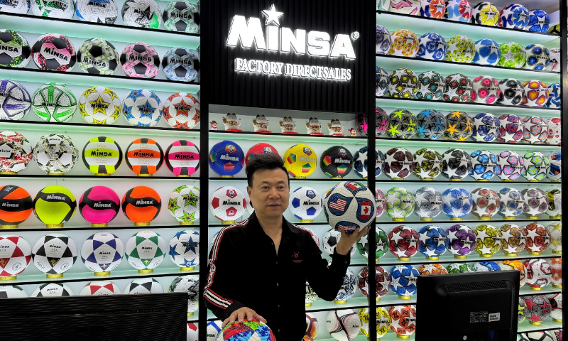 Chen Shaomei, manager of Minsa Sports in the Yiwu International Trade Market, displays two commemorative footballs designed for the 2026 FIFA World Cup that are most popular among overseas customers in Yiwu, East China's Zhejiang Province, on April 15, 2026. Photo: Courtesy of Chen Shaomei