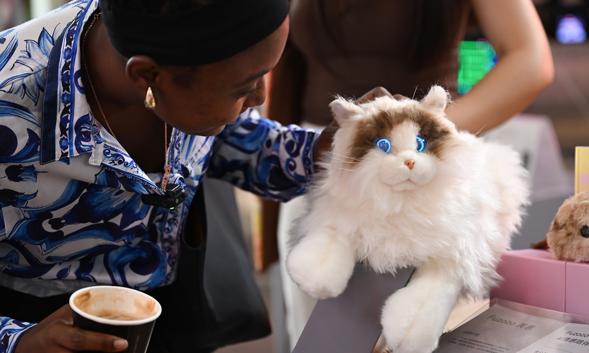 A foreign tourist interacts with an AI emotional companion robot at a digital trade and fashion consumption exhibition in Hangzhou, Zhejiang Province, on September 24, 2025. Photo: VCG