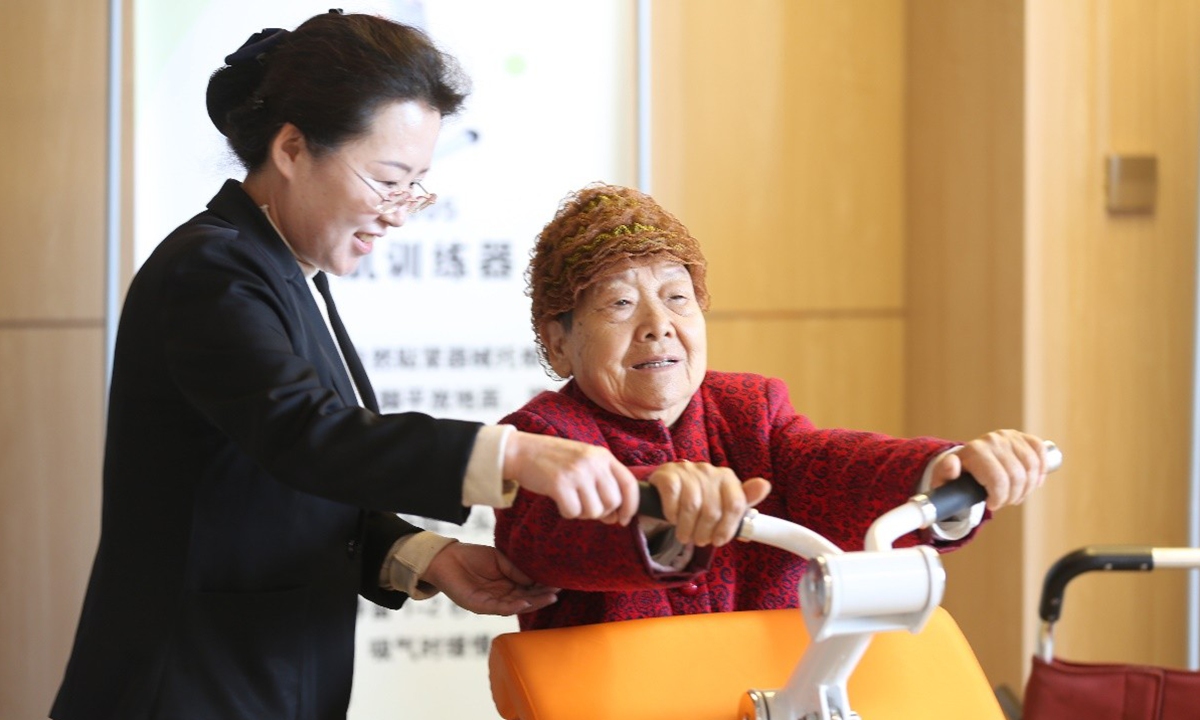 A staff member assists an elderly person with exercise at a fitness center in Rizhao, East China's Shandong Province. Photo: VCG