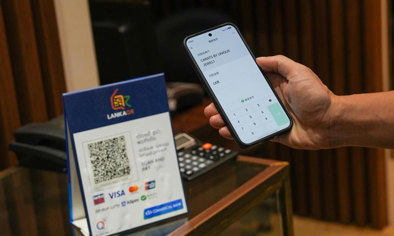 A customer makes a payment by scanning a local QR payment code with WeChat Pay at a shop in Colombo, Sri Lanka, April 23, 2026. (Photo by Thilina Kaluthotage/Xinhua)
