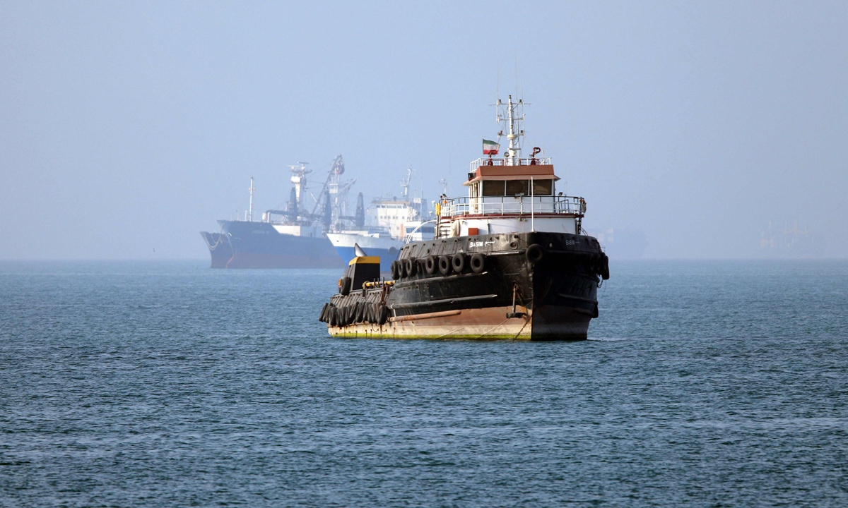 The Iran-flagged tugboat Basim sails near a ship anchored in the Strait of Hormuz off Bandar Abbas in southern Iran on May 4, 2026. Photo: VCG