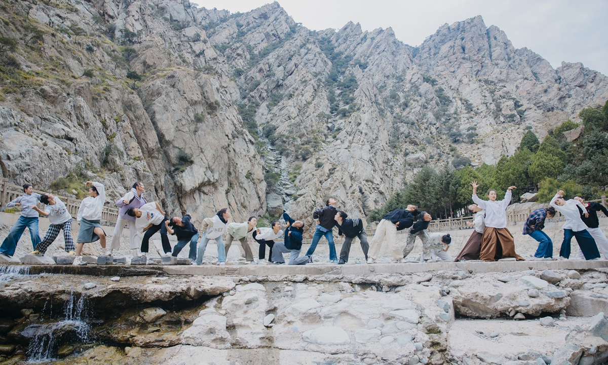 Performers practice dance movements near ancient rock paintings in Northwest China's Ningxia Hui Autonomous Region. Photo: Courtesy of Kang Lili