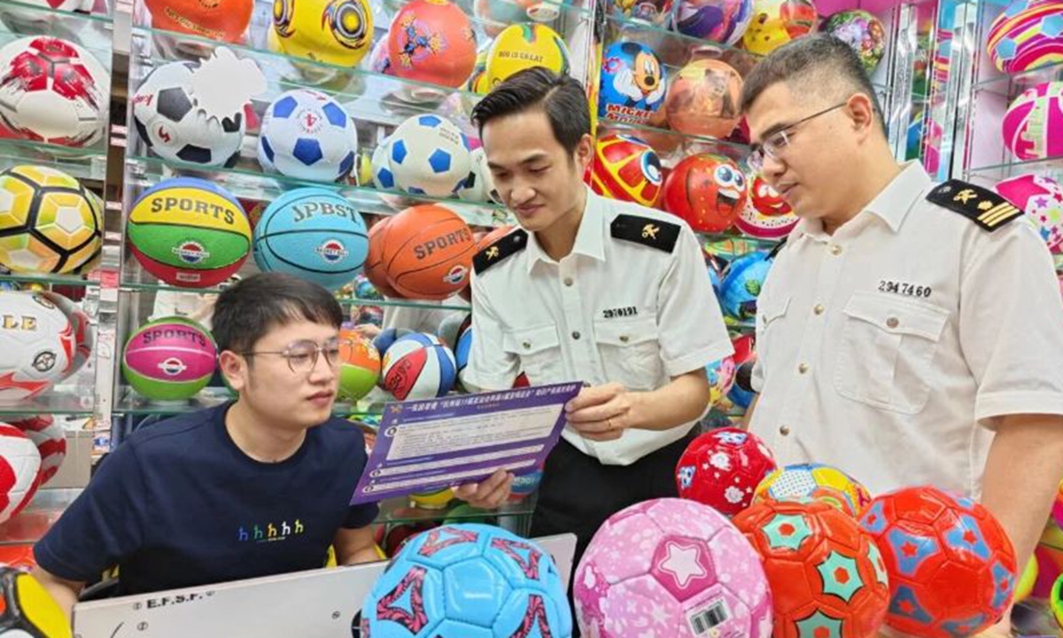 Customs officials talk with a merchant in Yiwu, the world's supermarket in East China's Zhejiang Province, ahead of the 2026 FIFA World Cup. Photo: Courtesy of Yiwu Customs