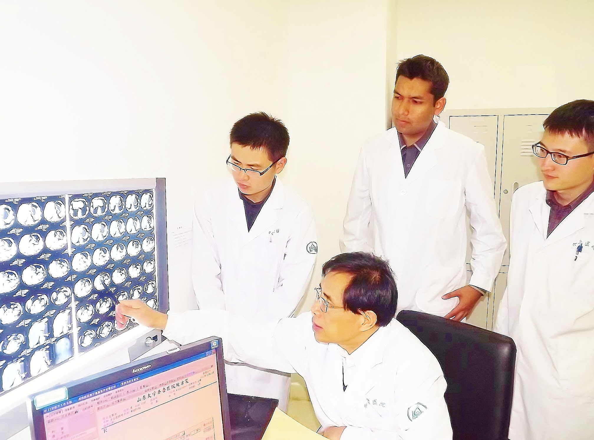 Muhammad Shahbaz (standing, center) looks at a scan with Professor Niu Jun and other doctors at Qilu Hospital of Shandong University in Jinan, China, 2010.