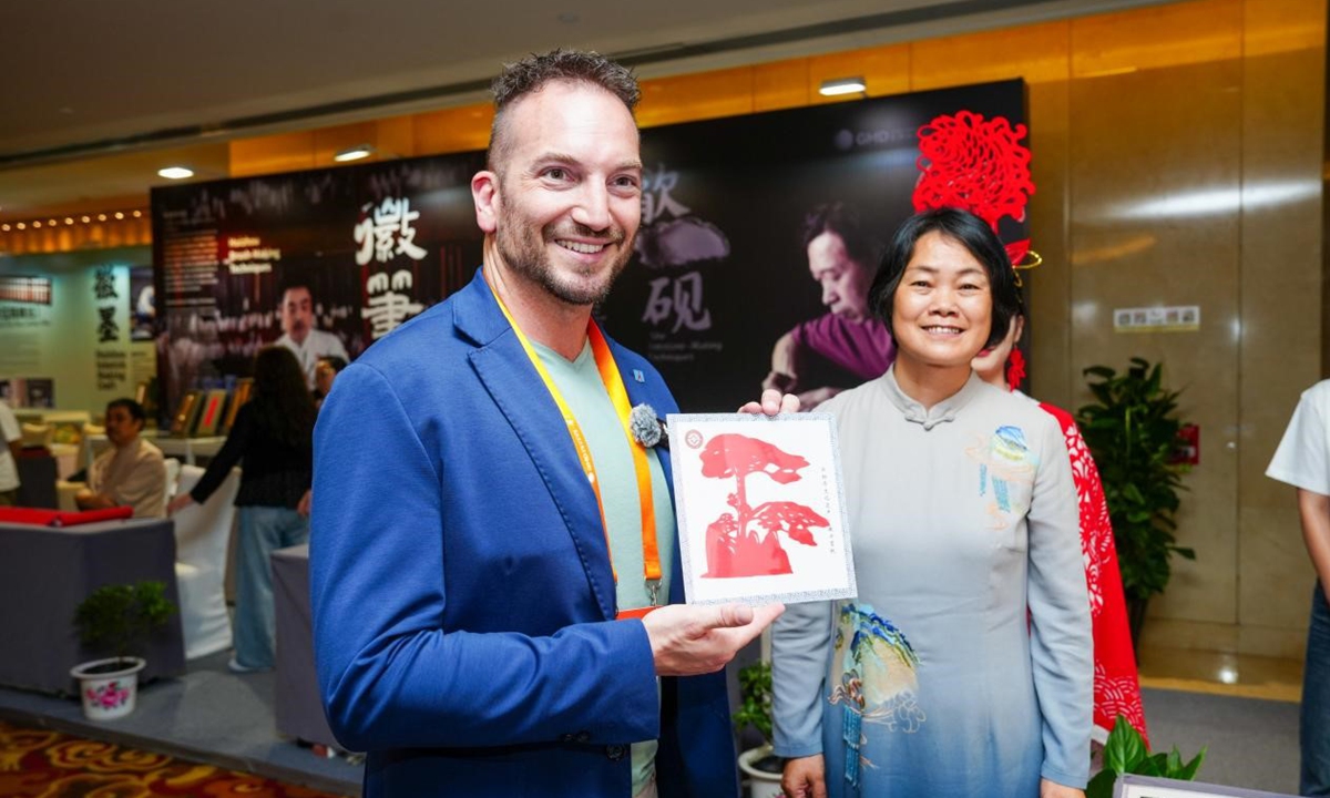 During the 2026 World Mayors Dialogue in Huangshan, East China's Anhui Province, a mayor learns paper-cutting from intangible cultural heritage inheritors. Photo: Courtesy of Global Mayors Dialogue