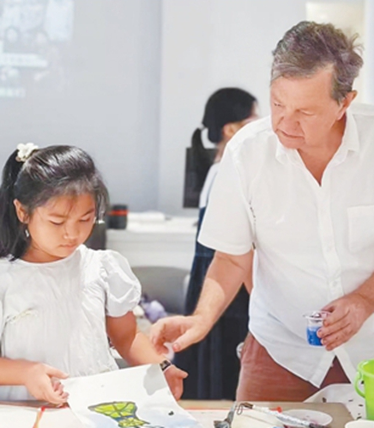 Australian artist David Reid creates an artwork with a girl. Photo: Courtesy of David Reid