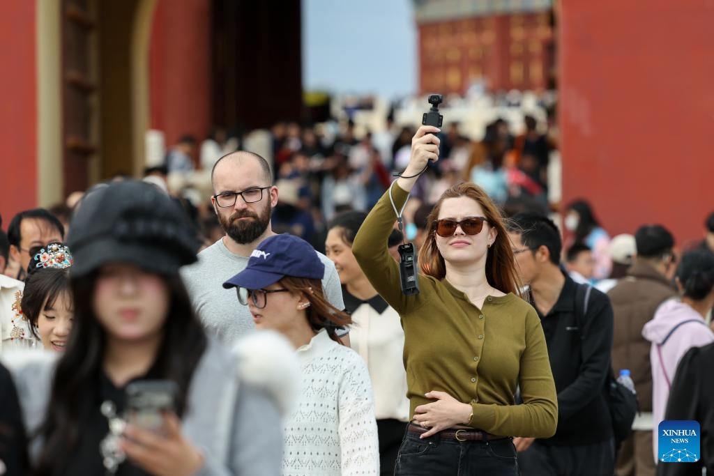 A foreign tourist records with a Chinese-brand pocket camera at the Temple of Heaven Park in Beijing, capital of China, May 2, 2026. Beijing received a total of 2.667 million inbound tourists in the first five months of this year, up 35.3 percent year-on-year, demonstrating the rising popularity of China Travel. As of May 11, the number of exits and entries by foreign nationals at Beijing ports had surpassed 2.55 million, accounting for 32 percent of the total inbound and outbound passenger volume and registering a year-on-year growth of 33.6 percent. (Photo: Xinhua)