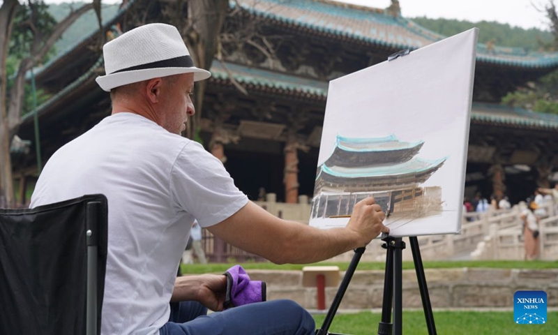 A Hungarian artist paints next to an ancient building in Taiyuan City, north China's Shanxi Province, June 18, 2026. A total of 23 artists, art educators, students and cultural professionals from Hungary wrapped up their discovery tour of the ancient architectural heritages in north China's Shanxi Province on Sunday. (Xinhua/Chen Zhihao)

